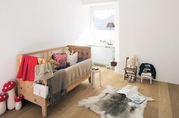 Rustikales Kinderzimmer mit Holzbett und Fell am Boden