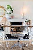 Grey office chair and desk in front of open fireplace with ornaments