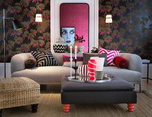 Wohnzimmer mit Polstermöbeln vor dunkler Blumentapete und Frauenportrait