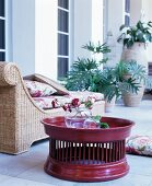 Elegant rattan couch with floral cushions next to claret tray table