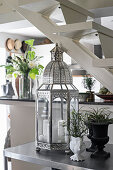 Oriental lantern and houseplants on console table under staircase