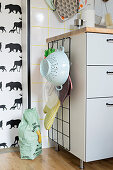 Wire mesh for hanging kitchen utensils on end of cabinet