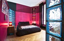 Hot-pink panelled walls and stucco ceiling in bedroom of period apartment