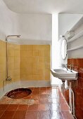 Badezimmer mit alten Fliesen und vertikalem Lichtschacht