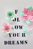 Origami flowers on paper printed with lettering