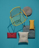 A yellow garden chair and decorative cushions made of robust outdoor fabrics