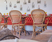 Red bench and vintage cane chairs in dining room
