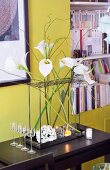Arrangement of white flowers on black console table against lime-green wall