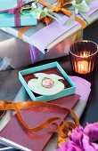 Lady's ring in turquoise gift box in front of stack of wrapped gifts