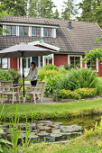 Teich und Terrassenplatz vor Schwedenhaus mit Gaubenfenster