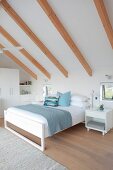 White, high-ceilinged attic bedroom