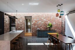 Küche und Esszimmer im Industriestil mit Backsteinwand