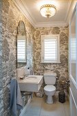 White WC, cistern and sink in guest toilet with patterned wallpaper