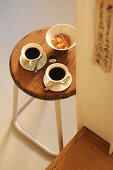 Two cups of coffee and bowl of sugar on retro stool
