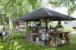 Outdoor kitchen with roof in summery garden