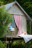 Romantic sleeping area on wooden terrace of rustic fisherman's hut