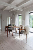 Sheepskins on designer chairs in dining room with white floor