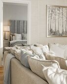 Kissensammlung auf Couch und Blick in elegantes Schlafzimmer