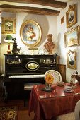 Antike Gemälde mit Goldrahmen über einem Klavier und Tisch