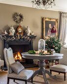 Upholstered chairs around pedestal table in front of open fireplace