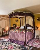 Antique four-poster bed with flounces in colourful bedroom