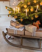 Verpackte Geschenke auf einem Schlitten unter dem Weihnachtsbaum