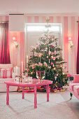 Christmas tree in kitsch living room decorated entirely in pink and hot pink