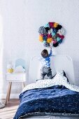 Children's room with dot pattern and wall decoration made of colorful pompoms