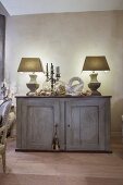 Two table lamps and peace dove ornament on vintage sideboard