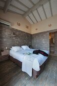 Schlafzimmer mit rustikalen Brettern an Boden und Wänden