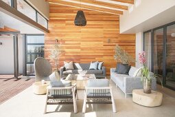 Wohnterrasse mit Designermöbeln in Grautönen und Holzverkleidung