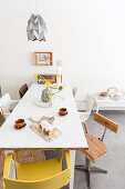 Various chairs around coffee and cake on white table
