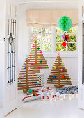Weihnachtsbäume aus Holzlatten mit bunter Deko aus Papier