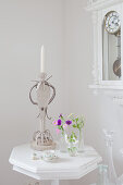 Kerzenhalter aus Wellpappe auf einem weißen Tischchen