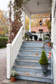 Autumn decorations on steps leading to veranda in Swedish country-house style