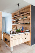 Open-plan fitted kitchen with plywood cupboards and island counter