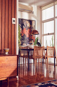 Wooden table and vintage chairs on shiny wooden floor in dining area