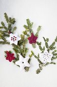 Various hand-made crocheted decorations on green fir branch