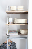 Storage baskets on shelves above clothes rail