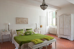 Green bedlinen and scatter cushions in vintage-style bedroom
