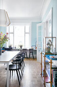 Dining room with pale blue walls in period apartment