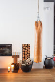 Punching bag suspended next to fireplace and firewood store