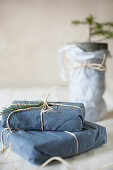 Gifts wrapped in blue fabric tied with parcel string