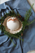 Angel on textured dish in wreath of larch twigs