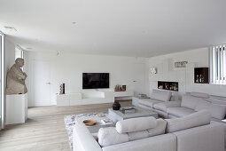 Hellgraue Sofalandschaft im minimalistischen Wohnzimmer
