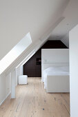 Minimalistisches Schlafzimmer mit Einbauschrank unter dem Dach