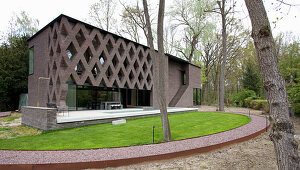 Halbrunder Rasen um ein modernes Architektenhaus mit offener Fassade