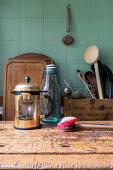 Worn washing-up brush and kitchen utensils on wooden table