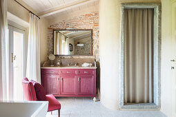 Claret-red washstand cabinet and chair in Mediterranean bathroom