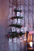Weihnachtsbaum aus Tannenzweigen mit Weihnachtswünschen in verschiedenen Sprachen